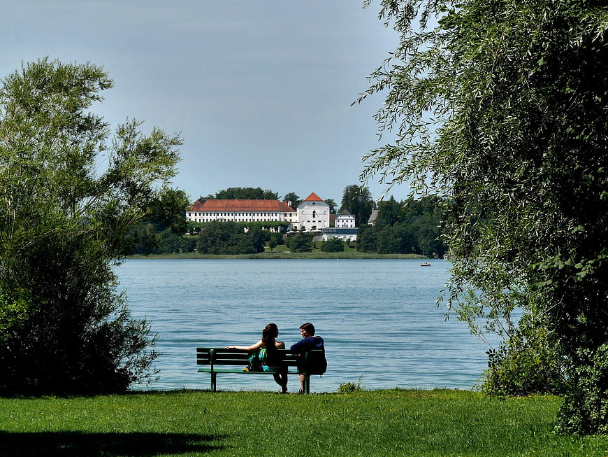 Couple sitting on bench overlooking lake with castle in distance