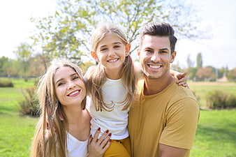 Happy family portrait in a sunny park