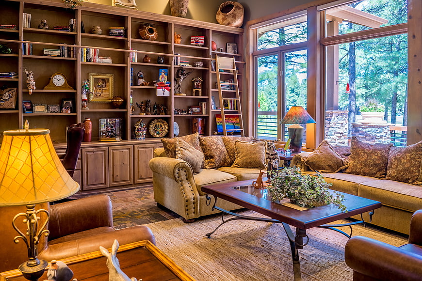 Cozy rustic living room with built-in bookshelves and forest view