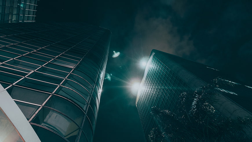 Low angle view of modern glass skyscrapers at night
