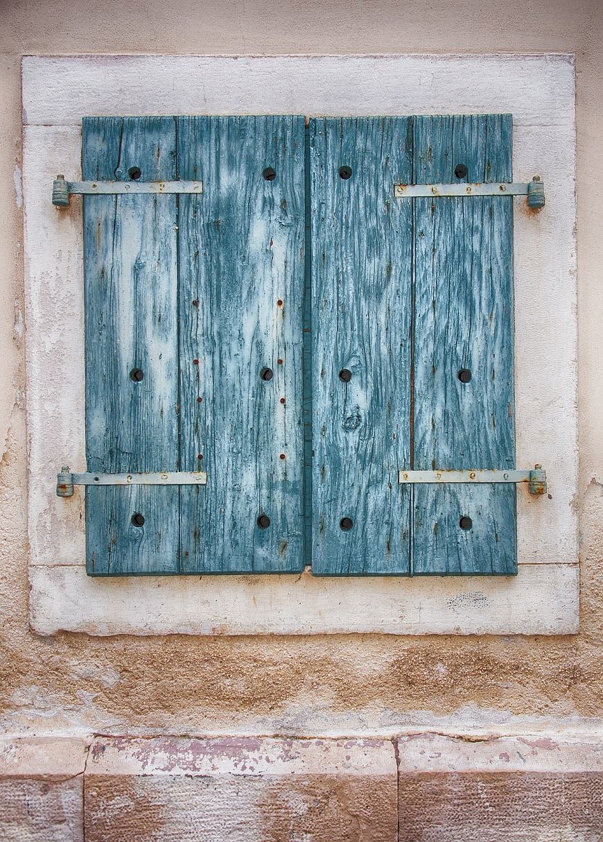 Weathered Blue Wooden Shutters on Textured Wall