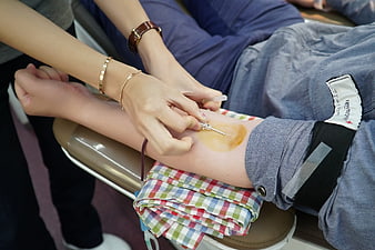Close-up of blood donation procedure with needle insertion