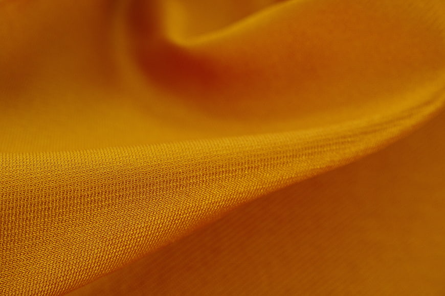 Close-up of textured orange fabric with soft folds