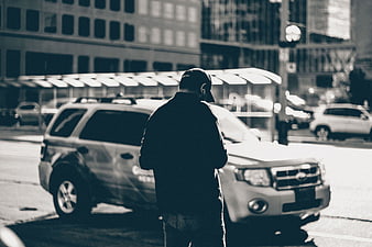 Man in Cap Standing by Car on City Street