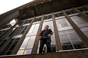 Low angle shot of young man standing in front of modern building