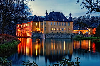 Moated Castle Reflection at Dusk with Warm Illumination