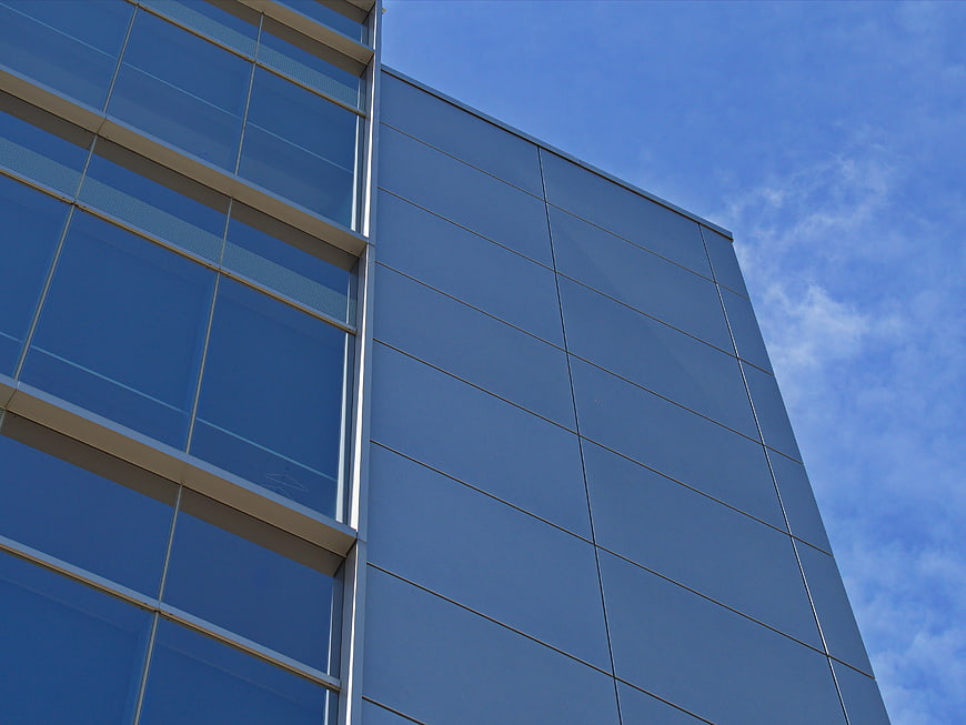 Modern Glass Office Building Facade Against Blue Sky