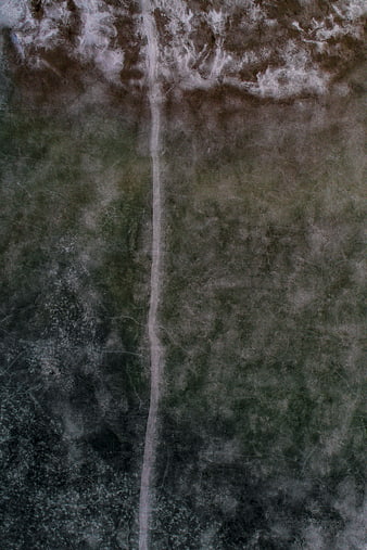 Aerial view of a dirt path through a textured landscape