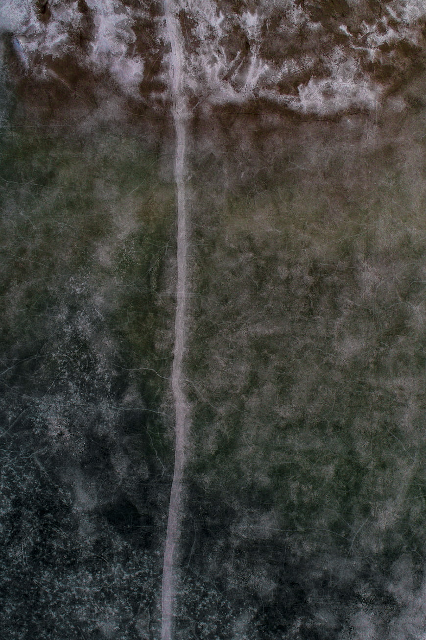 Aerial view of a dirt path through a textured landscape