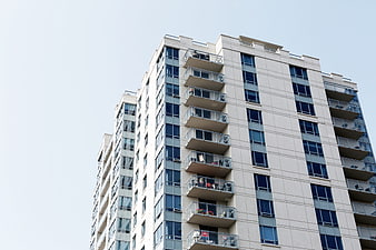 Modern Apartment Building with Balconies Against Blue Sky