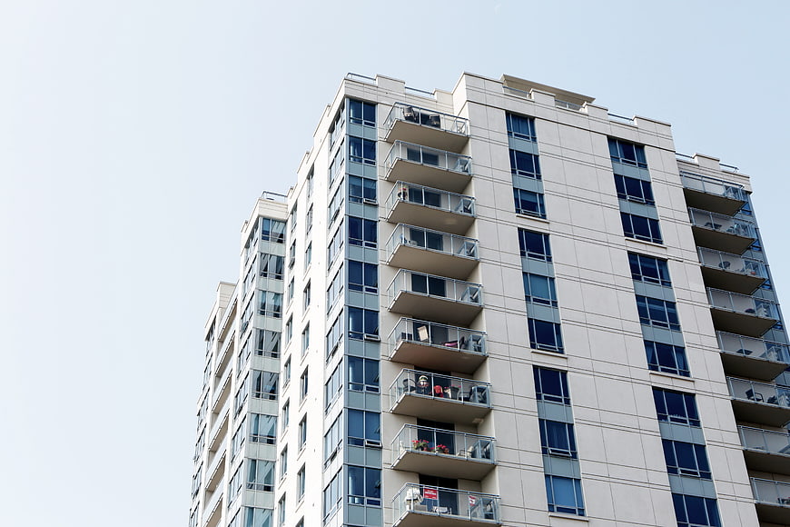 Modern Apartment Building with Balconies Against Blue Sky