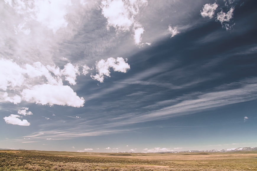 Vast open landscape with dramatic clouds and distant mountains