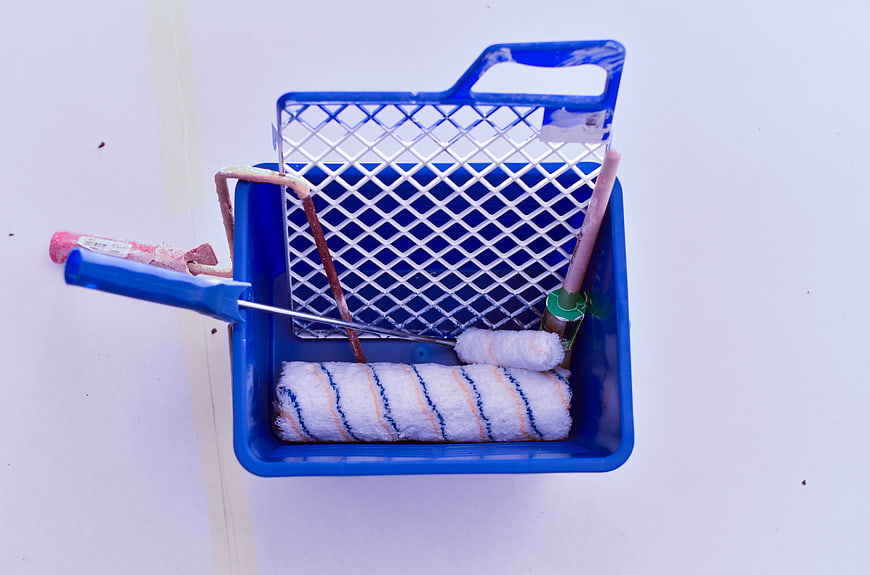Blue Paint Tray with Rollers and Tools on White Background