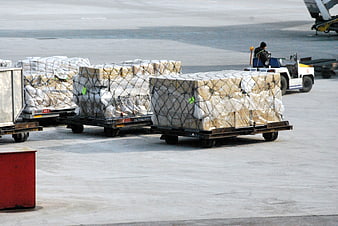 Airport cargo pallets being towed on tarmac