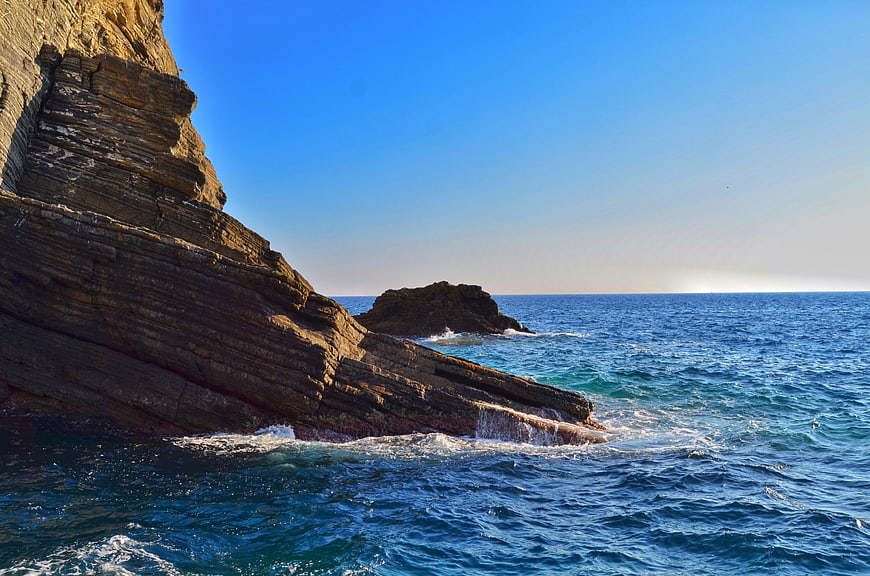 Dramatic rocky coastline with blue sea and clear sky
