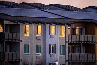 Modern Apartment Building with Solar Panels at Sunset