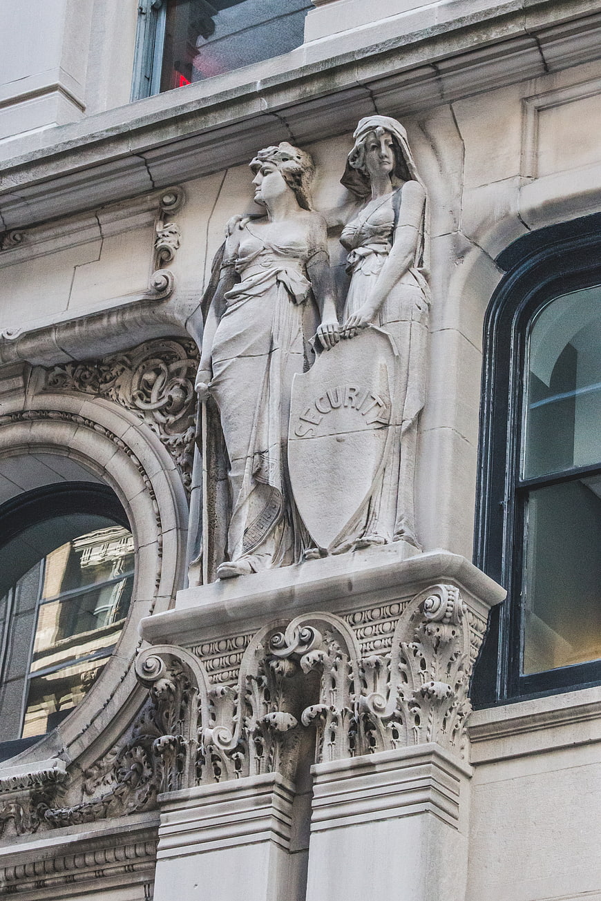 Ornate Stone Sculpture of Two Women on Historic Building Facade
