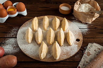Homemade dumplings on wooden board with ingredients