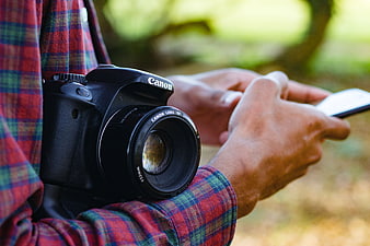 Photographer with DSLR Camera and Smartphone Outdoors