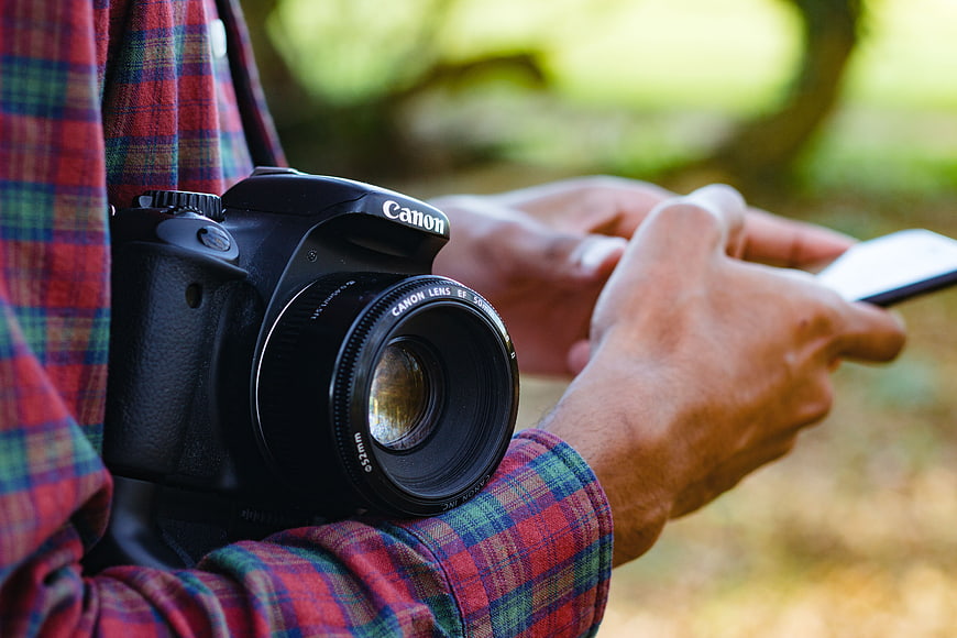 Photographer with DSLR Camera and Smartphone Outdoors