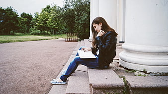 Young Woman Writing in Notebook on Stone Steps