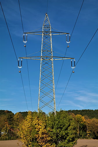 High Voltage Power Line Tower Against Blue Sky