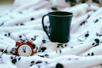 Cozy Morning Scene with Alarm Clock and Coffee Mug on Blanket