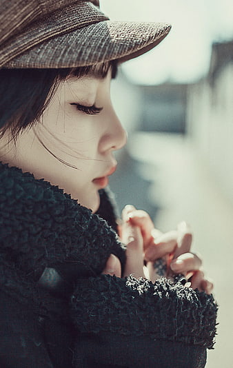 Close-up of Woman in Hat and Coat with Hands Clasped