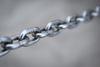 Close-up of silver metal chain links on gray background