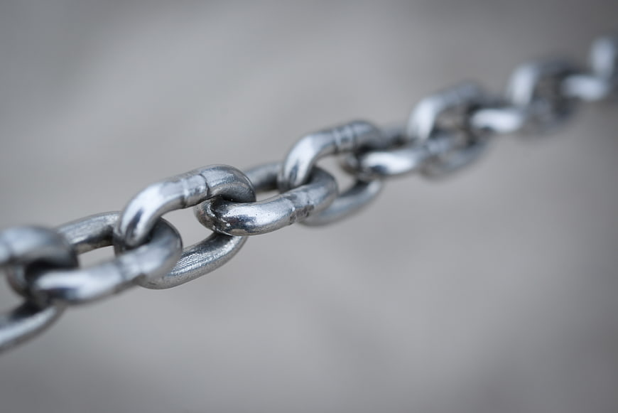 Close-up of silver metal chain links on gray background