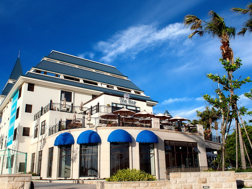 Modern white building with blue awnings and rooftop tea bar