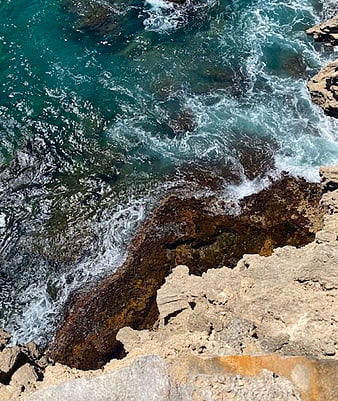Aerial View of Turquoise Waves Crashing on Rocky Coastline