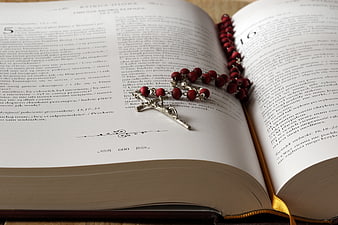 Red Rosary on Open Bible with Polish Text