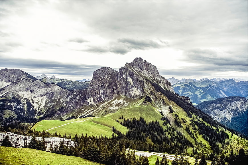 Majestic mountain peak with green slopes and cloudy sky