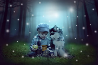Young boy and husky puppy sitting in a magical snowy forest
