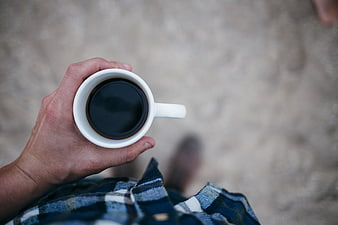 First-person view of hand holding coffee cup