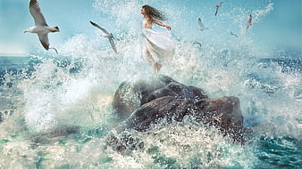 Woman in white dress standing on rock amidst crashing ocean waves