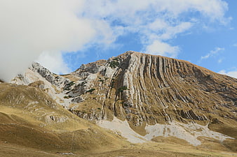 Majestic Mountain Peak with Rocky Cliffs and Blue Sky