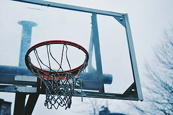 Close-up of outdoor basketball hoop against overcast sky