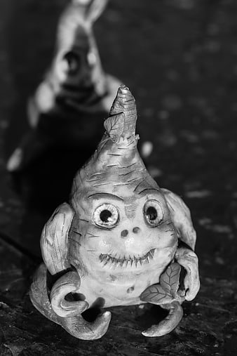 Black and white photo of whimsical clay monster figurine