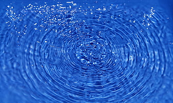Blue water ripples and splash impact close-up