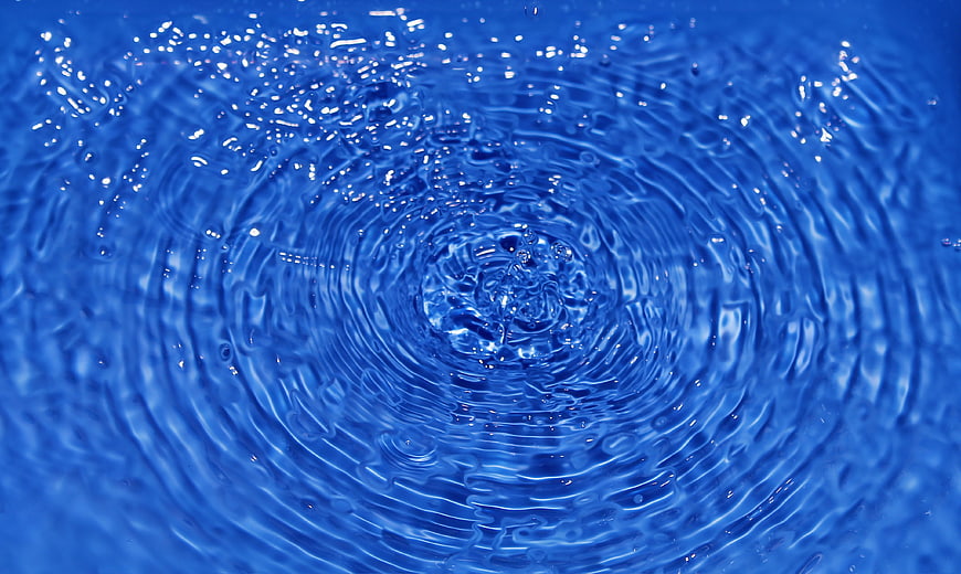 Blue water ripples and splash impact close-up