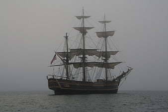 Historic Three-Masted Schooner Sailing in Foggy Ocean Waters