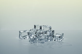 Stack of melting ice cubes on white background