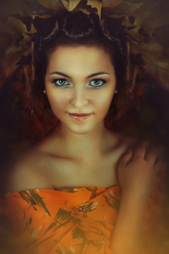 Portrait of a woman with blue eyes and autumn leaves