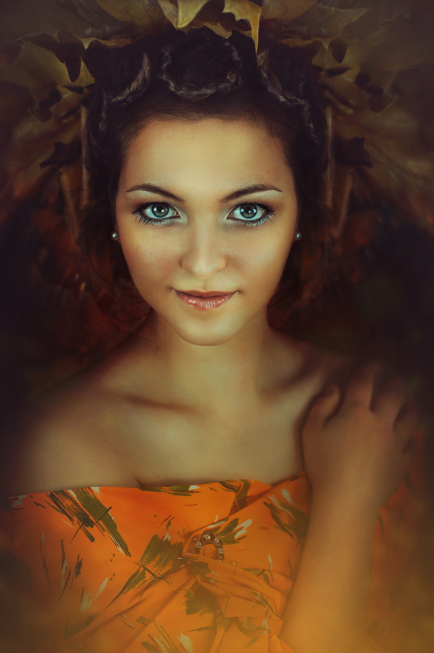 Portrait of a woman with blue eyes and autumn leaves