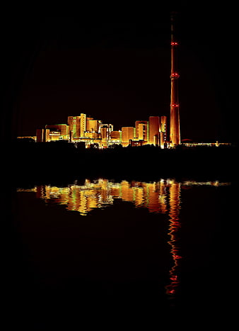 Illuminated Power Plant at Night with Water Reflection