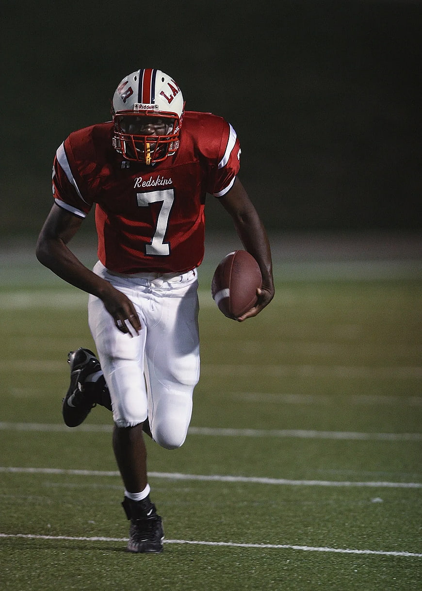 American Football Player Running with Ball at Night
