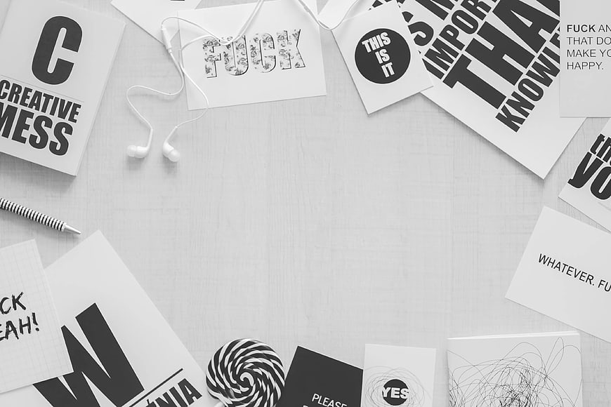 Minimalist black and white flat lay with typographic cards and headphones