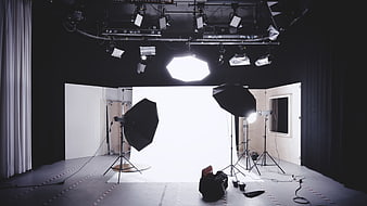 Professional photography studio with lighting equipment and white backdrop